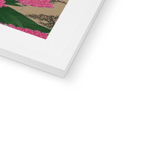 A picture of a picture frame holding a cherry blossom on top of a flower bed