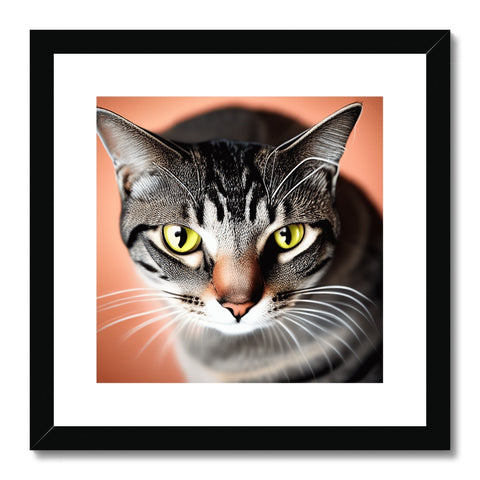 a brown and green tabby sitting next to a frame with a cat photo on the