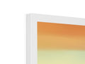 There is a picture of an iMac MacBook sitting next to a picture frame.