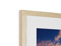 A picture of a blue sky framed in a photograph in a wooden frame.