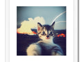 A little kitten playing with a photo on the page of a picture.