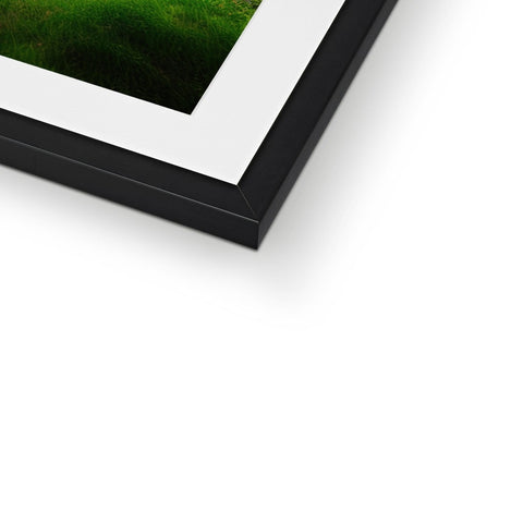 A picture frame with an image of a green field sitting on top of a wall is