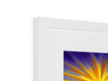 A picture frame with a picture of sunrise in a window with a sunburst scene on