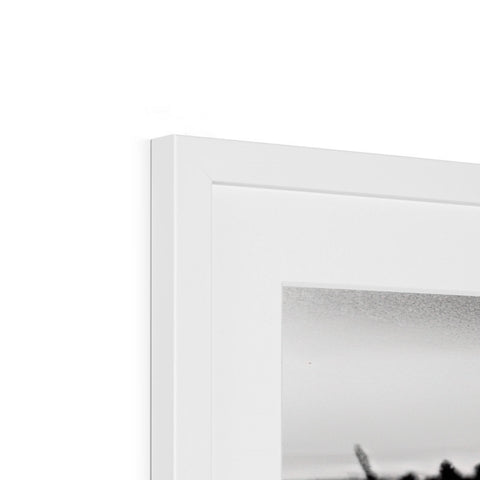 A white picture frame sitting above a white table.