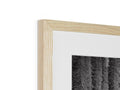 A black and white photo frame on the wood frame on a white wall.