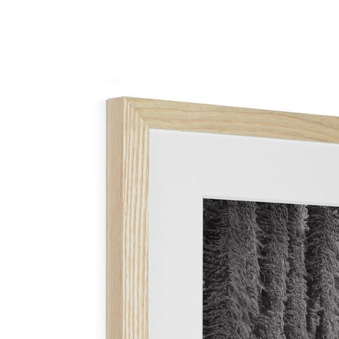 A black and white photo frame on the wood frame on a white wall.