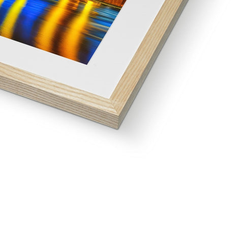 A picture of an abstract photograph in a wooden frame on a white table with a piece