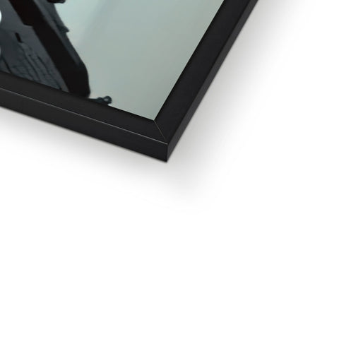 A photo of a picture frame with a black mirror on the bottom that a chair sits