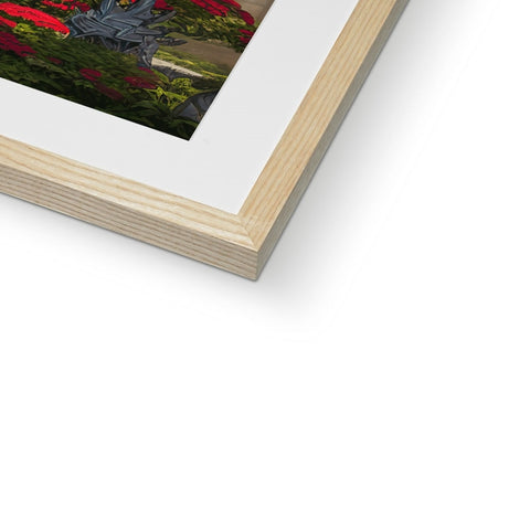 A picture of a red flower in a metal frame in front of a white picture frame