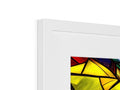 A white picture frame and yellow art print with various colors displayed in it.
