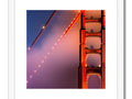 A metal framed photo of a bridge with a golden gate.