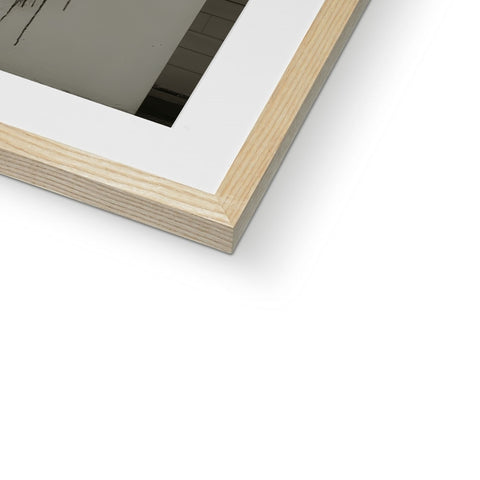 An image of another picture frame looking white and framed above a frame with a wooden frame
