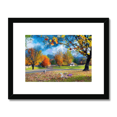 A colorful photo on a white print of trees filled with fall foliage.