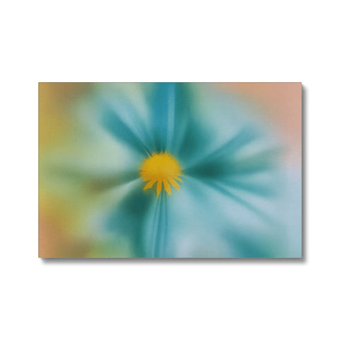 A white flower on the canvas with a blue and yellow print.