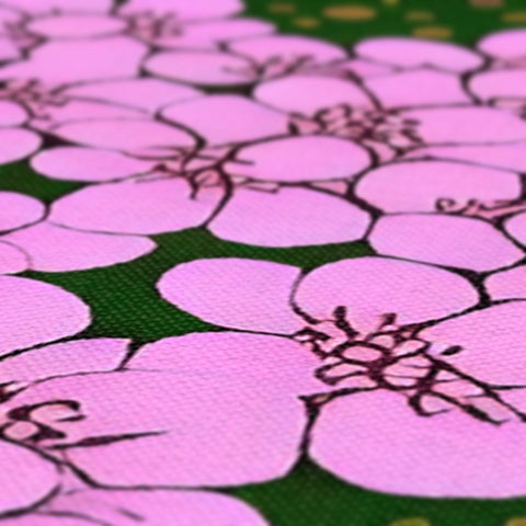 A tablecloth covered with pink flowers on one side of a black wooden table.