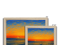 A picture frames of a scene with a sunset against a white background.