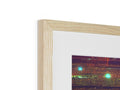A photo is in a wooden frame with a photo of trees inside of it.