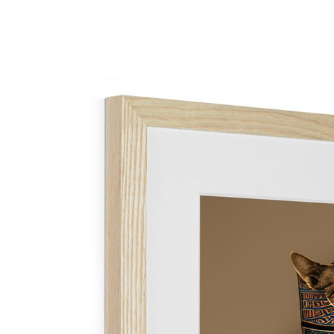 A cat peeking into a photo frame of a wooden object