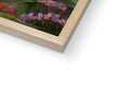 A wooden picture frame that contains various tropical plants in a color palette.