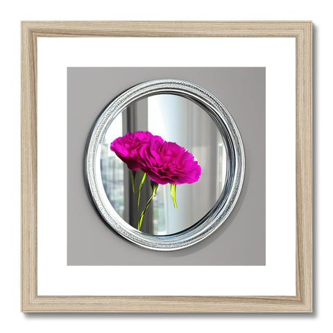 a framed photograph is placed on a frame next to a mirror with a flower, a