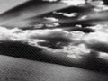 A piece of black and white and white fabric above clouds.