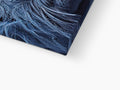 A folded towel on a blue comforter in a dining room with an art print