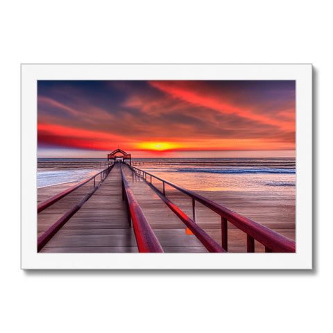 A large colorful art print of a sunrise on a beach next to a sand dune