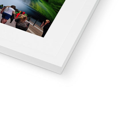 The image of a white picture frame on top of a frame is holding four photographs.