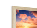 A wooden picture frame with photos of a tree and the sun is in the background.