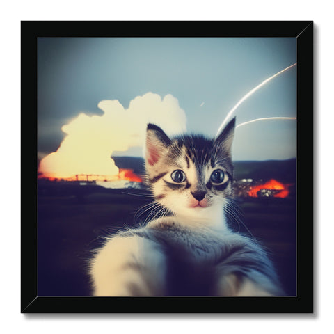 A kitten playing on the top of a picture that has a frame.