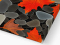 Glass tiles sitting on top of a wooden countertop with some autumn leaves.
