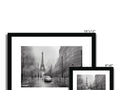 A picture frame with a black and white photo that has two of a cityscape on