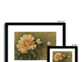 A picture frame on a white wall with three gold flowers framing a picture frame with a