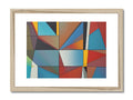 A white framed piece of art on a wall with three little colored geometric designs.