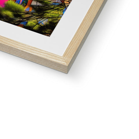An art print in a frame sits on a piece of wood.
