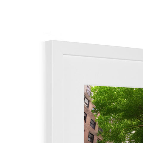 A picture frame for a photo standing over a window with some trees and a table.