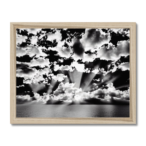 A picture of a dark and cloudy sky framed in wooden frame with art.