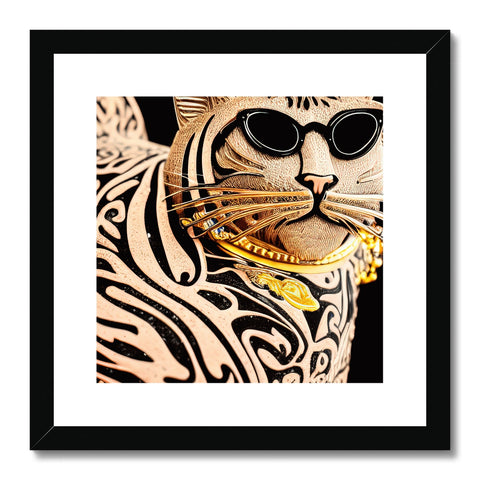 A gold cat sits in front of an art print that is framed in black.
