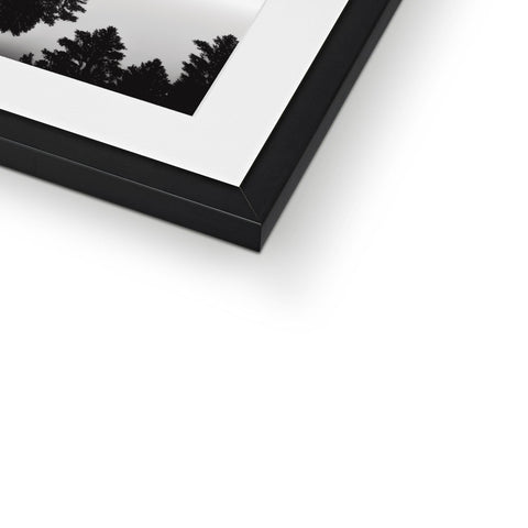 a picture frame with black frame with a shot and white background is on a white wall