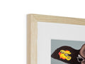 A wooden frame holding a photograph of a golliwog with a bird on it