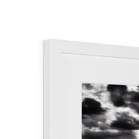 Picture frame with black and white photograph of the sky and a white background.