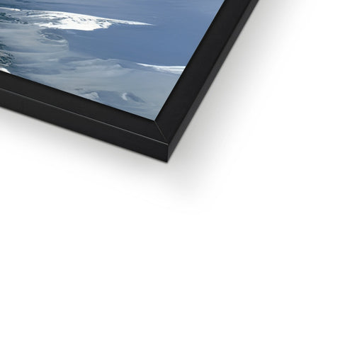 A picture frame displayed on top of a dark wall with a white glass and black picture