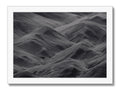 A black and white art print of a beach with white waves.