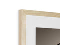 A wooden picture frame on a wall holding a black and white picture of an object.