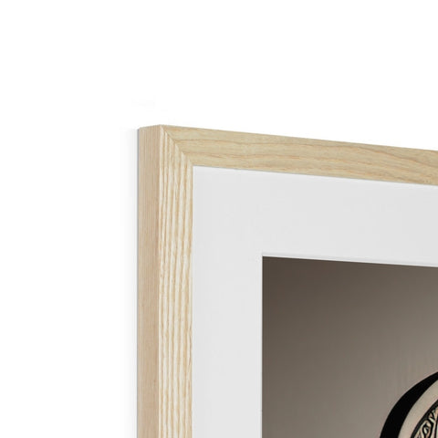 A wooden picture frame on a wall holding a black and white picture of an object.