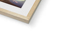 A wood picture frame hanging on top of a picture of a book next to a white