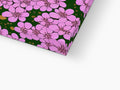 A pillow that has a pink skirt covered by a small flower on the side.