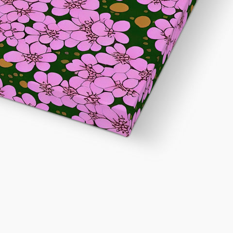 A pillow that has a pink skirt covered by a small flower on the side.