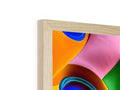A framed picture of an abstract painting sitting on a wooden shelf.