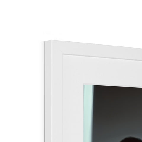 A white picture frame that is in a window on top of a glass wall.